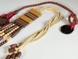 a brown and white necklace with beads on a white table