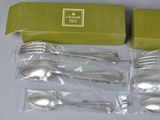 silverware in a green box on a table with a box of silverware in the background
