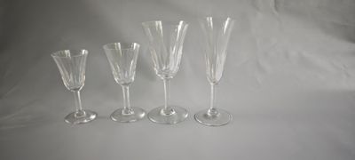 quatre verres à vin vides sont alignés sur une surface blanche