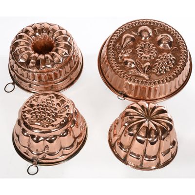 three copper plated cake pans and a cake pan on a white background