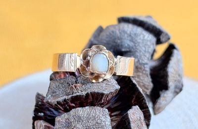 une bague en or surmontée d'une pierre blanche