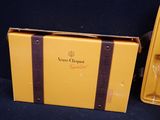 a yellow suitcase sitting next to a bottle of wine