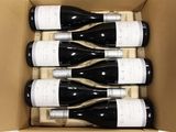 six bottles of wine in a cardboard box on a table