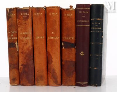 several old books are lined up in a row on a white surface