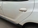 a small white car parked on the side of the road