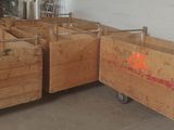 Plusieurs caisses en bois sont empilées les unes sur les autres dans un entrepôt