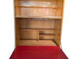a red desk with a book shelf on top of it