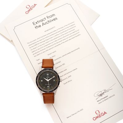 une montre posée sur une feuille de papier, à côté d'une autre feuille de papier