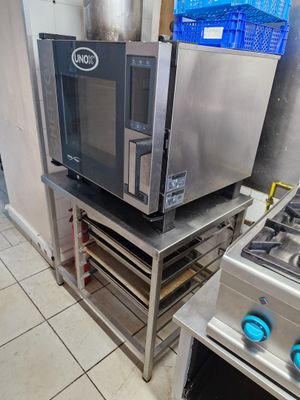 a microwave sitting on top of a metal shelf in a kitchen