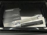 a black box with two pens and a book in it