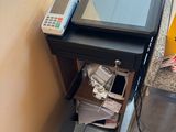 une petite table sur laquelle sont posés une imprimante et un téléphone portable