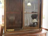 un vaisselier en bois muni d'une porte vitrée sur le dessus