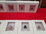 several boxes of different types of rocks on a red surface