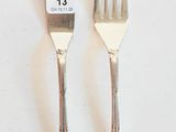 deux fourchettes et un couteau sur une table blanche