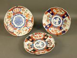 three plates with different designs on them sitting on a table