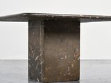a concrete table with a metal base on a concrete floor