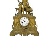 une horloge en or sur laquelle figurent un homme et un chien
