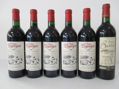 six bottles of red wine lined up in a row on a table