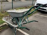 une brouette sur un parking, à côté d'une voiture