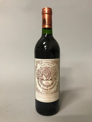 une bouteille de vin posée sur une table blanche