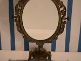 a mirror on a stand with a blue and white striped wall behind it