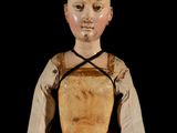 an old doll with a red dress and a white shirt