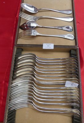 beaucoup de cuillères et de fourchettes dans une boîte posée sur une table