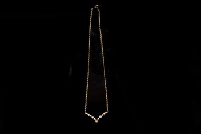 un gros plan d'un collier suspendu à une chaîne dans l'obscurité