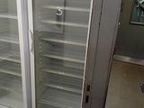 two refrigerators that are open in a room