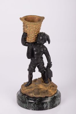 une image représentant la statue d'un garçon portant un panier sur la tête