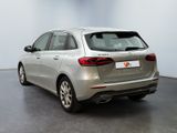 the rear end of a silver car in a white room