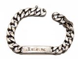 un gros plan sur un bracelet en argent sur lequel figure un prénom