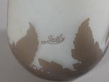 a close up of a vase with leaves on it
