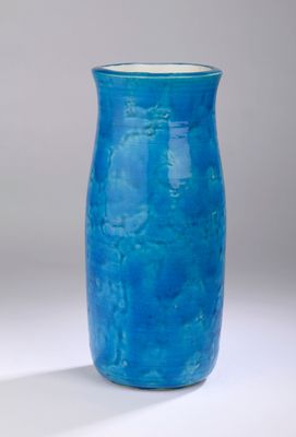 a blue vase that is sitting on a white surface