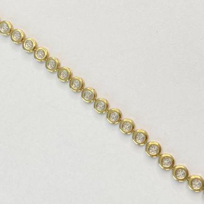 un gros plan d'un bracelet en or serti de diamants sur un fond blanc