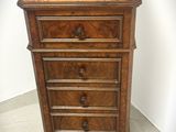 une petite commode en bois surmontée de tiroirs
