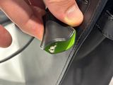 a person holding a black purse with a green handle
