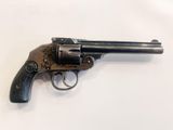 a small revolver with a wooden handle on a white surface