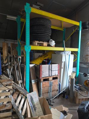un garage rempli de cartons et avec un pneu posé sur une étagère