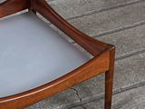 a small wooden table with a glass top on a brick floor