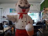 un chef gonflable géant dans un décor de cuisine