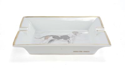un cendrier en forme de chien, blanc et doré, orné d'un chien noir et blanc