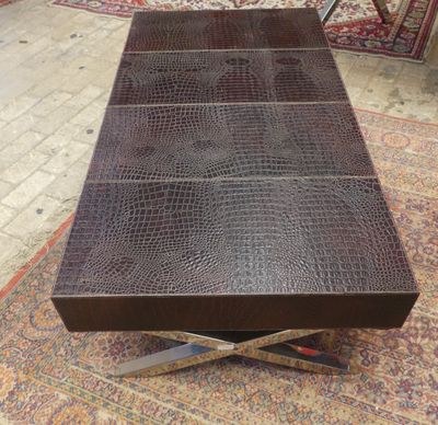 Une TABLE basse piètement en X chromés et dessus gainé en cu…