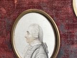three framed portraits of a man and a woman on a red velvet surface