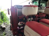 a red and white tractor parked in a garage