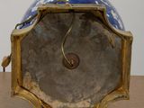a blue and gold clock sitting on top of a wooden table
