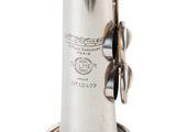 silver plated musical instrument on a stand on a white background