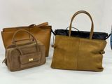 three bags are lined up on a white surface and one is brown and the other is tan