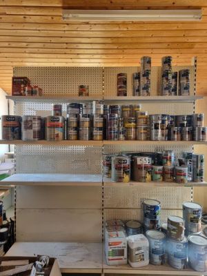 a shelf full of paint and other items in a room