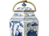 a blue and white vase with a brass handle